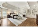 Spacious main bedroom with a tray ceiling, fireplace, built-in shelving, and sitting area at 157 Lake Forrest Ne Ln, Atlanta, GA 30342