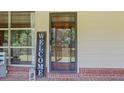 Welcoming front porch with a welcome sign and view into the home's screened porch and surrounding nature at 347 Oakhurst Dr, Marietta, GA 30066