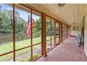 Enclosed porch with brick floor, offering serene pond views and fresh air from ample windows at 347 Oakhurst Dr, Marietta, GA 30066