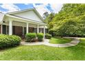 Inviting front porch with brick facade, elegant columns, and a curved walkway at 11270 Stroup Road, Roswell, GA 30075