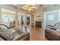 Elegant living room featuring coffered ceilings, hardwood floors, a cozy fireplace, and comfortable leather sofas at 3255 Clear View Dr, Snellville, GA 30078