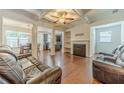Elegant living room featuring coffered ceilings, fireplace, hardwood floors, and comfortable leather seating at 3255 Clear View Dr, Snellville, GA 30078