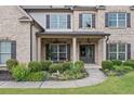 Inviting front entrance featuring a cozy sitting area and decorative landscaping at 4460 Hunters Walk Way, Cumming, GA 30028