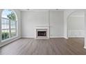 Bright living room featuring a fireplace, large window, and sleek flooring at 3025 Andora Sw Dr, Marietta, GA 30064