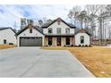 Beautiful modern farmhouse with stylish dark trim, covered porch, and a spacious driveway at 3609 Centerville Rosebud Rd, Snellville, GA 30039