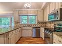 Updated kitchen boasts granite counters, stainless appliances, and hardwood flooring, with a view of nature at 4655 Barnes Ct, Loganville, GA 30052