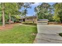 Spacious two-story home with a large front yard, attached two-car garage, and mature trees at 4794 Glenbonnie Ct, Atlanta, GA 30360