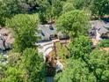 Aerial view of ranch-style home with a long driveway, surrounded by lush greenery, near a golf course at 511 Pine Valley Se Rd, Marietta, GA 30067