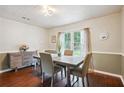 Elegant dining room featuring a modern table, decorative ceiling, and ample natural light from the window at 285 Aspen Way, Fayetteville, GA 30214