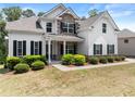 Charming two-story home with stone accents, a covered porch, lush landscaping, and a well-manicured lawn at 2855 Pilgrim Mill, Cumming, GA 30041