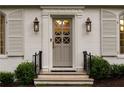 Close-up of the front door with decorative glass, sconces, and classic molding at 3916 E Brookhaven Ne Dr, Brookhaven, GA 30319