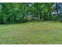 Charming home exterior nestled among trees with a well-manicured lawn at 911 White Stag Ln, Canton, GA 30115