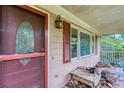 Charming front porch featuring a vintage door, red shutters, and an overhead light fixture at 911 White Stag Ln, Canton, GA 30115