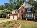 Charming brick and siding two-story home with well-manicured lawn, landscaping, and a two-car garage at 1415 Stoney Field Pl, Lawrenceville, GA 30043