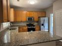 Well-lit kitchen featuring granite countertops, stainless steel appliances, and ample cabinet space at 1415 Stoney Field Pl, Lawrenceville, GA 30043