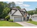 Lovely home featuring a pristine lawn, attached garage, and mature trees offering ample shade and curb appeal at 9811 Spyglass Dr, Villa Rica, GA 30180