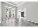 Bright living room with a bay window, hardwood floors, neutral paint, and an open doorway to the foyer at 9811 Spyglass Dr, Villa Rica, GA 30180