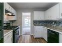 Kitchen featuring white cabinets, modern appliances, and a stylish backsplash at 12015 Harbour Town Pkwy, Fayetteville, GA 30215