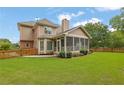 The backyard features a fenced yard, a screened in porch, and mature trees at 1304 Swallows Walk, Grayson, GA 30017