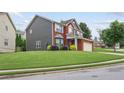 Charming two-story home with gray siding, brick facade, two-car garage, and spacious front lawn at 1657 Bradmere Ln, Lithia Springs, GA 30122