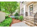 Charming brick home entrance with manicured landscaping, stairs, and a decorative front door at 4202 Deming Cir, Sandy Springs, GA 30342