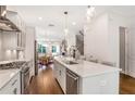 Bright, modern kitchen featuring a large island, stainless appliances, and open layout to dining area at 4202 Deming Cir, Sandy Springs, GA 30342