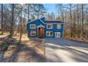 Charming two-story home with a blue exterior, complemented by a spacious front yard and mature trees at 2139 Logan Dr, Jonesboro, GA 30236