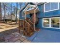 Side view of a house with a charming wooden staircase, an orange door, and blue siding at 2139 Logan Dr, Jonesboro, GA 30236