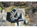 Aerial view of a multi-story home with an intricate roofline, surrounded by mature trees and parked vehicles at 3265 Greenhill Ct, Villa Rica, GA 30180
