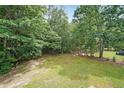 A peaceful, green backyard surrounded by mature trees and lawn at 3265 Greenhill Ct, Villa Rica, GA 30180