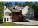 Charming home with a two-story layout, a front-facing garage, and a covered porch with stone detailing at 3265 Greenhill Ct, Villa Rica, GA 30180