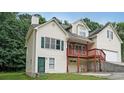 A charming home with a two-story layout, a front-facing garage, and a red porch with stone detailing at 3265 Greenhill Ct, Villa Rica, GA 30180