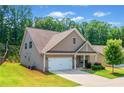 Side view of a craftsman-style home with a well-maintained lawn and a two-car garage at 151 Rolling Hills Pl, Canton, GA 30114