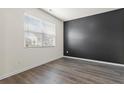 Minimalist bedroom with wood-look floors, a large window, and stylish accent wall at 2296 Waycross Ln, Dacula, GA 30019