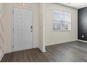 Bright entryway featuring wood-look floors, a modern white door, and natural light at 2296 Waycross Ln, Dacula, GA 30019