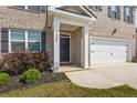 Inviting front entrance with a black door, lush landscaping, and a Ring doorbell at 2296 Waycross Ln, Dacula, GA 30019