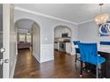 Modern dining room with hardwood floors, arched entryway, and stylish chandelier at 5880 Garden Circle Cir, Douglasville, GA 30135