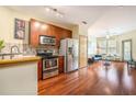 Modern kitchen with stainless steel appliances, wood cabinets, and an open view into the living room at 898 Oak Sw St # 3420, Atlanta, GA 30310