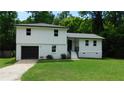 Charming two-story home features a fresh exterior paint, attached garage, and well-maintained front lawn at 9148 Homewood Dr, Riverdale, GA 30274
