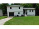 Charming two-story home features a fresh exterior paint, attached garage, and well-maintained front lawn at 9148 Homewood Dr, Riverdale, GA 30274