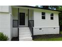 Inviting front porch with painted stairs, modern railings, and a stylish black front door at 9148 Homewood Dr, Riverdale, GA 30274