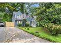 Blue two-story house with landscaped yard, a bright yellow door, and a private driveway at 233 Spence Se Ave, Atlanta, GA 30317