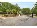 Gated community entrance featuring mature landscaping, a black metal gate, and well-maintained surroundings at 185 Beracah Sw Walk, Atlanta, GA 30331