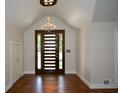 Grand foyer featuring a modern front door, hardwood floors, and a stylish chandelier at 2116 Strasburg Ct, Atlanta, GA 30338