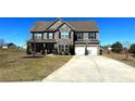 Beautiful two-story home with stone accents, a basketball hoop, a well-manicured lawn, and a long driveway at 3227 Puritan Way, Mcdonough, GA 30252