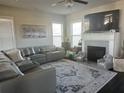Spacious living room boasts a plush sectional sofa, a fireplace with a mantel, and large windows for ample light at 3227 Puritan Way, Mcdonough, GA 30252