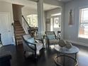 Cozy living room featuring stylish accent chairs, dark hardwood floors, and a glimpse into the dining area at 3227 Puritan Way, Mcdonough, GA 30252