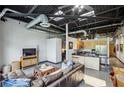 Spacious open concept living area with exposed ceiling and a modern kitchen island at 5200 Peachtree Rd # 3420, Atlanta, GA 30341