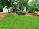 Inviting home with a lush green lawn, mature trees, and a side-entry garage at 1003 River Plantation Dr, Woodstock, GA 30188