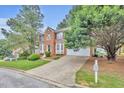 Attractive two-story brick home with lush landscaping, bay windows, and a convenient two-car garage at 1138 School Side Dr, Lithonia, GA 30058